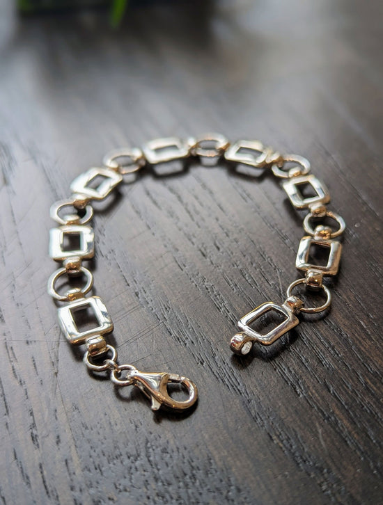 Photo of Square and Circle Fancy Link Bracelet in a decorative scene, designed by , available at Plumb Gold & Plumb Silver