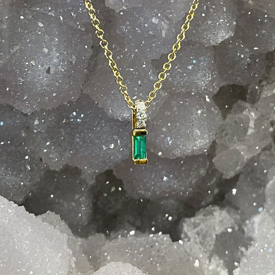 Photo of Stanton Color Emerald and Diamond Pendant in a decorative scene, designed by , available at Plumb Gold & Plumb Silver