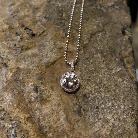 Photo of Stanton Color Morganite Halo Pendant in a decorative scene, designed by , available at Plumb Gold & Plumb Silver
