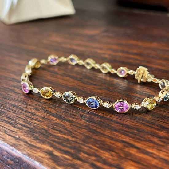 Photo of Stanton Color Rainbow Sapphire Bracelet in a decorative scene, designed by , available at Plumb Gold & Plumb Silver
