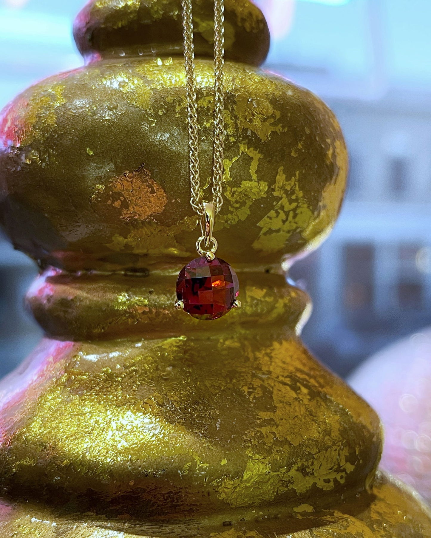 Photo of Stanton Color Red Garnet Pendant in a decorative scene, designed by , available at Plumb Gold & Plumb Silver