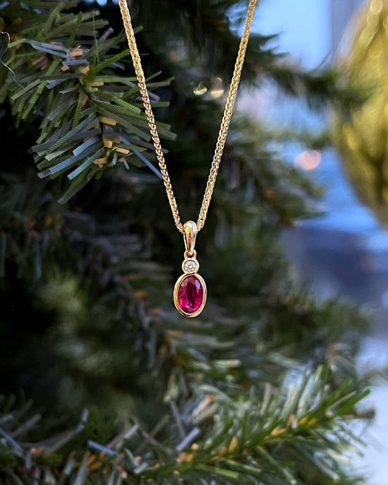 Photo of Stanton Color Ruby and Diamond Pendant in a decorative scene, designed by , available at Plumb Gold & Plumb Silver