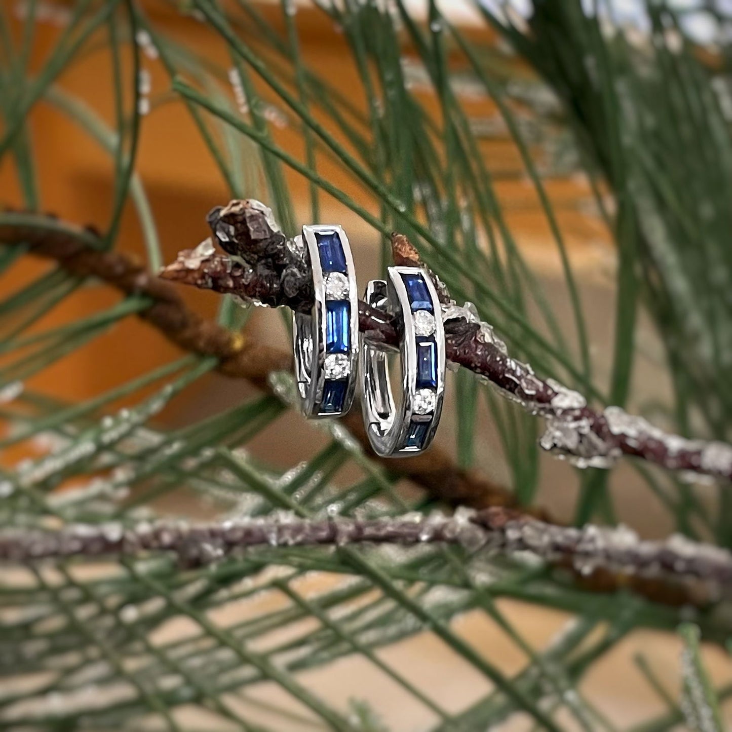 Photo of Stanton Color Sapphire and Diamond Hoops in a decorative scene, designed by , available at Plumb Gold & Plumb Silver