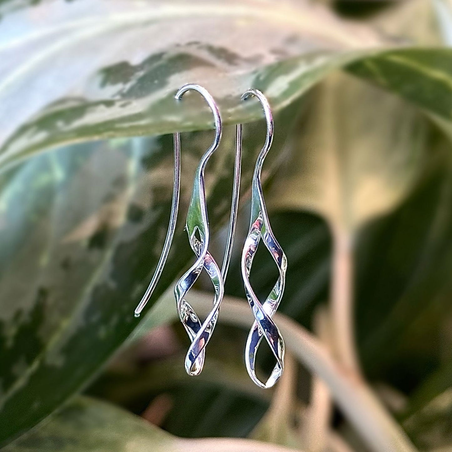 Photo of Swizzle Earrings in a decorative scene, designed by , available at Plumb Gold & Plumb Silver