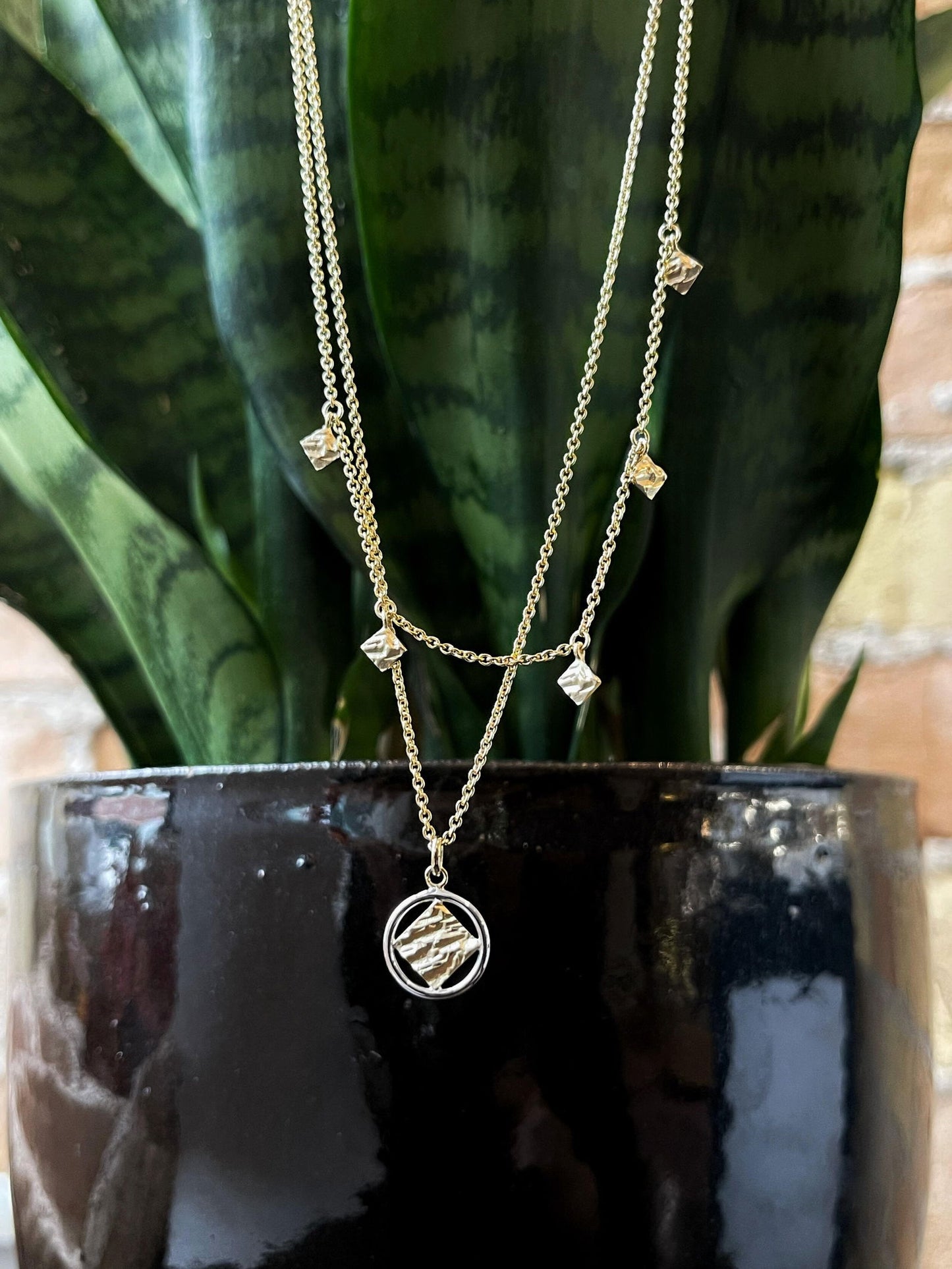 Photo of Textured Layered Necklace in a decorative scene, designed by , available at Plumb Gold & Plumb Silver