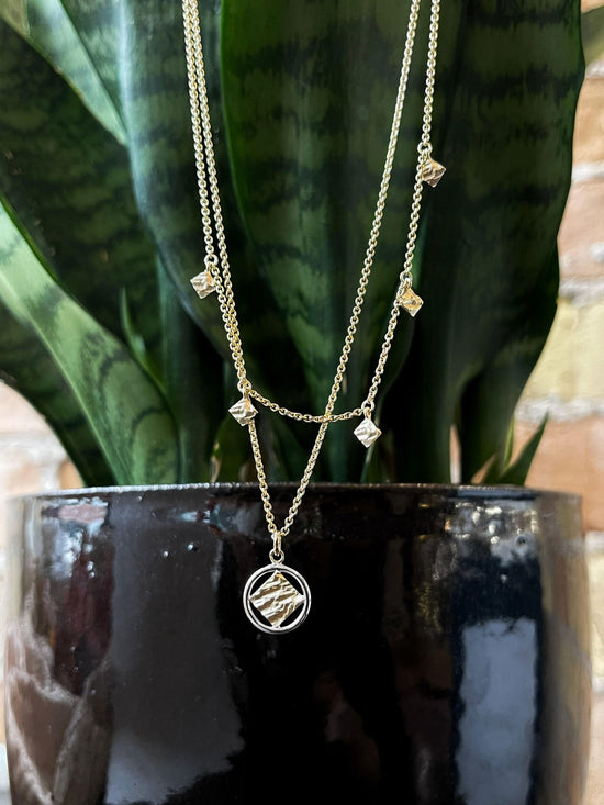 Photo of Textured Layered Necklace in a decorative scene, designed by , available at Plumb Gold & Plumb Silver