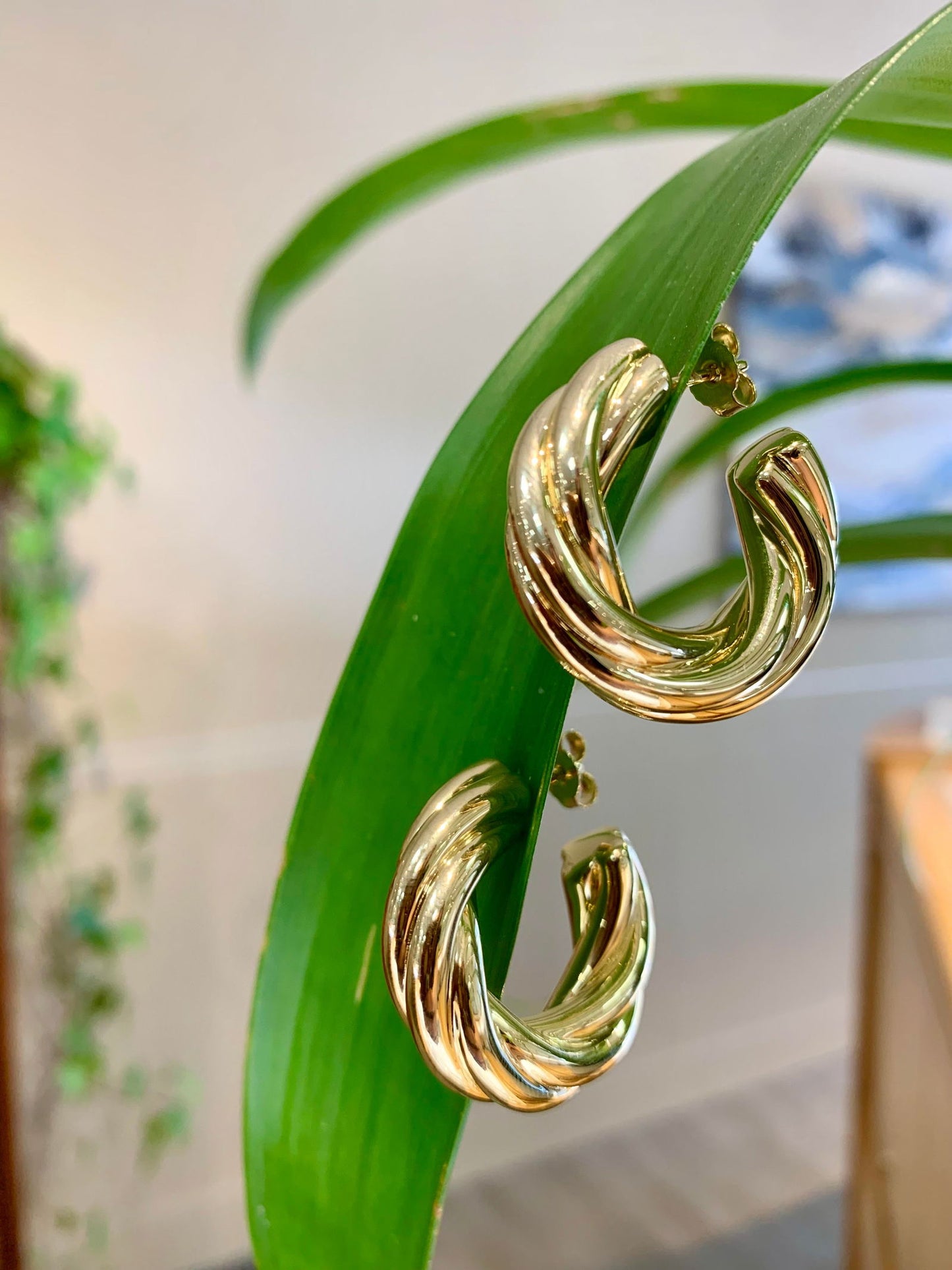 Photo of Thick Twisted Hoop in a decorative scene, designed by , available at Plumb Gold & Plumb Silver