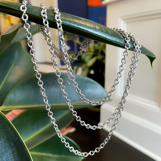Photo of Three Strand Chain Necklace in a decorative scene, designed by , available at Plumb Gold & Plumb Silver