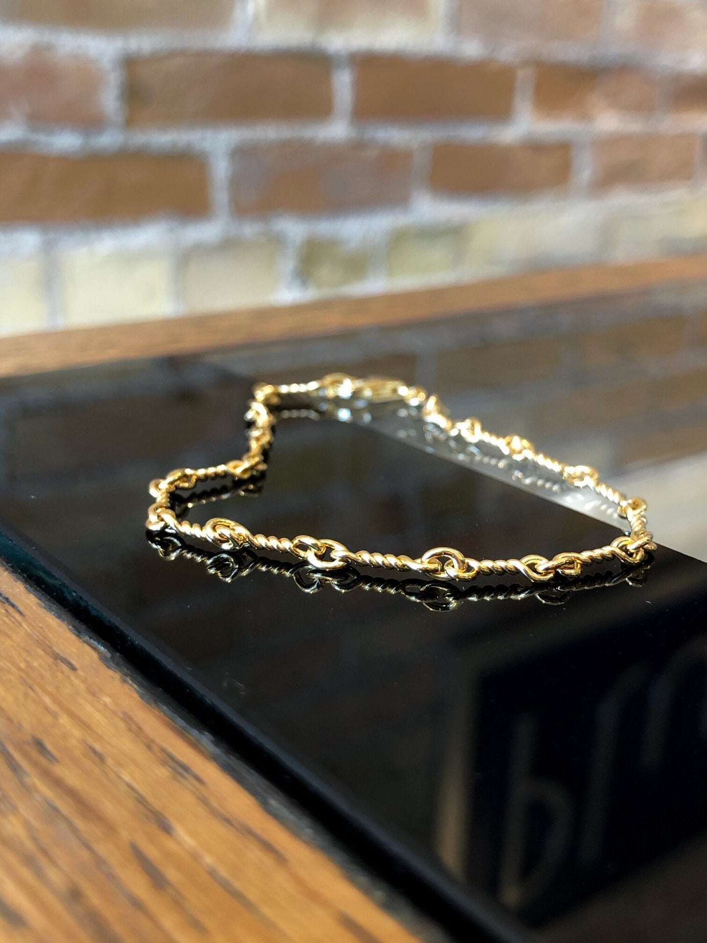 Photo of Twisted Link Bracelet in a decorative scene, designed by , available at Plumb Gold & Plumb Silver