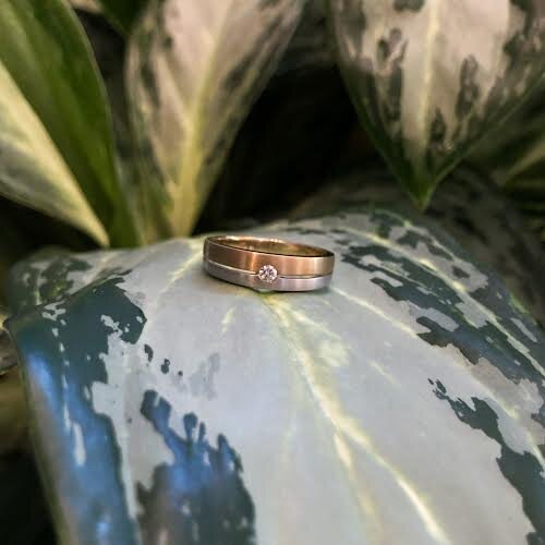 Photo of Two-Tone Double Line Ring in a decorative scene, designed by , available at Plumb Gold & Plumb Silver