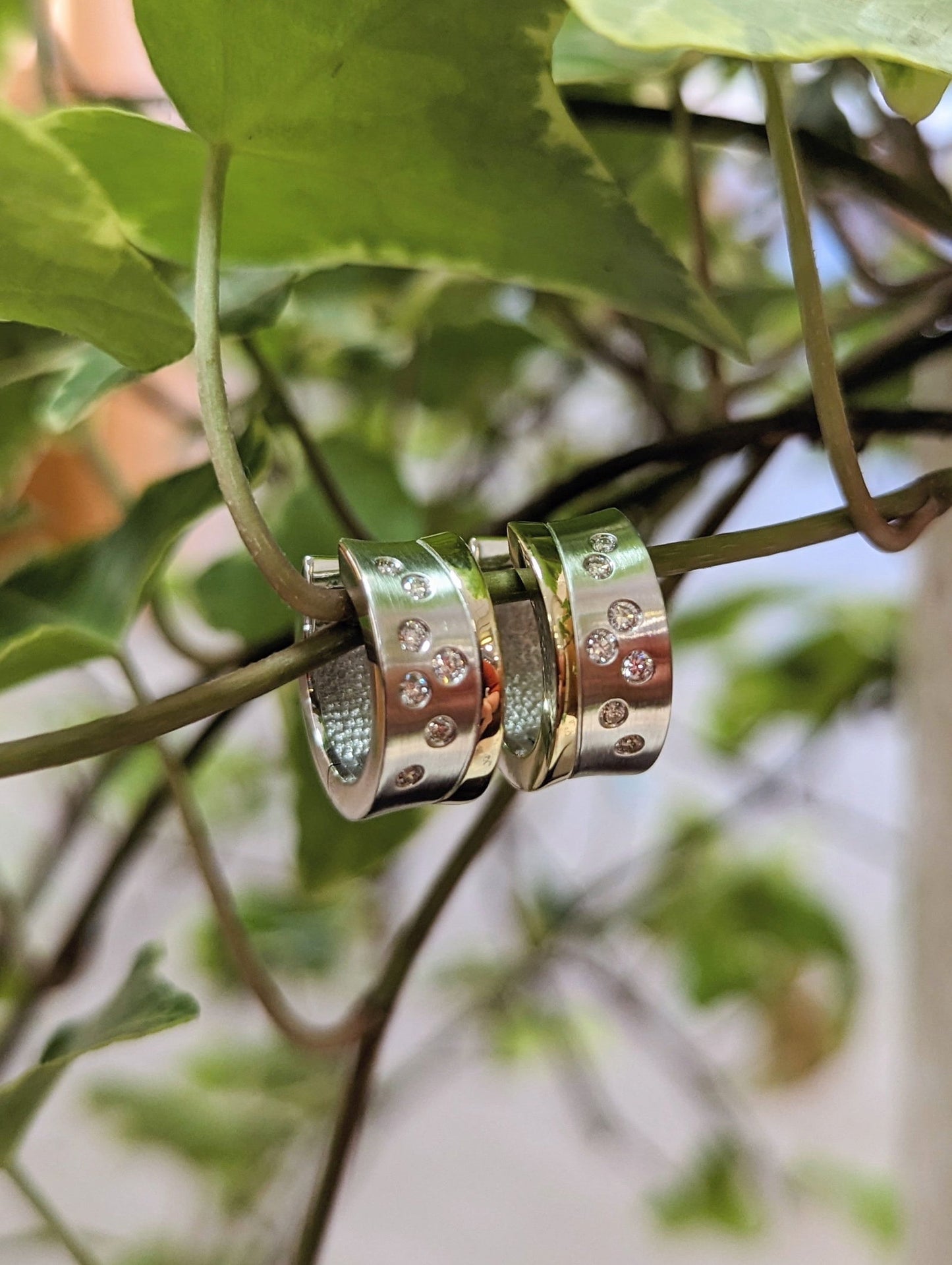 Photo of Two-tone Modern Accented Huggie Earrings in a decorative scene, designed by , available at Plumb Gold & Plumb Silver