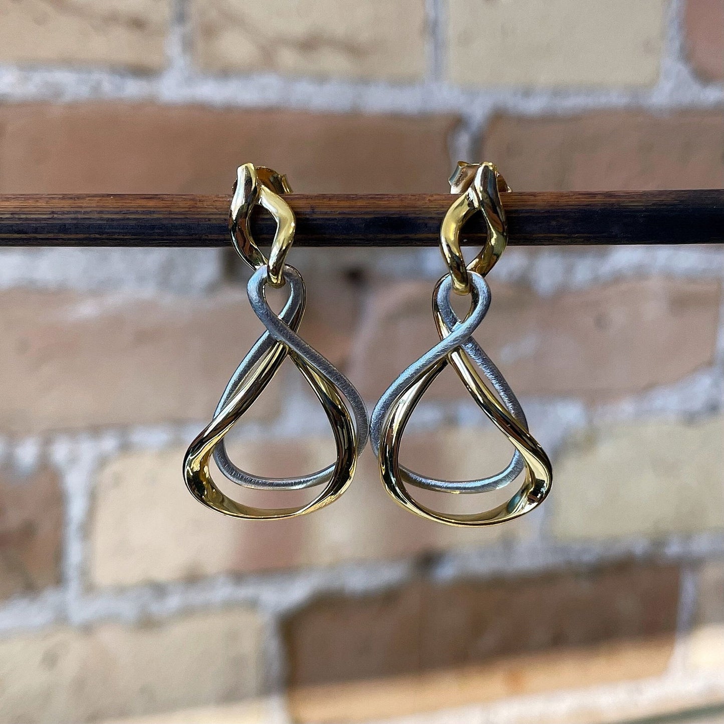 Photo of “Venice” Two Tone Dangles in a decorative scene, designed by , available at Plumb Gold & Plumb Silver