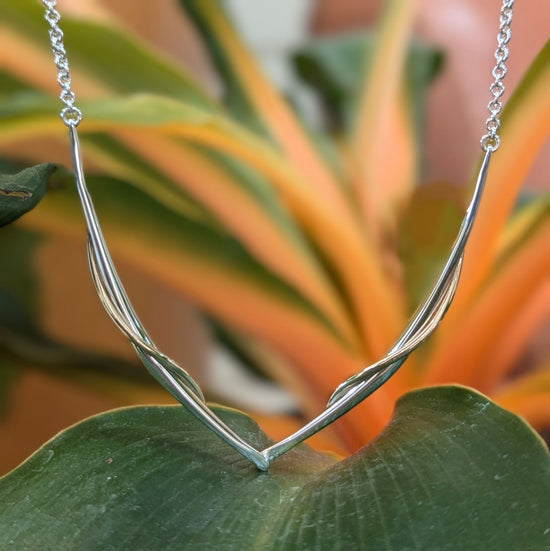Photo of "Vineyard Swing" Necklace in a decorative scene, designed by , available at Plumb Gold & Plumb Silver
