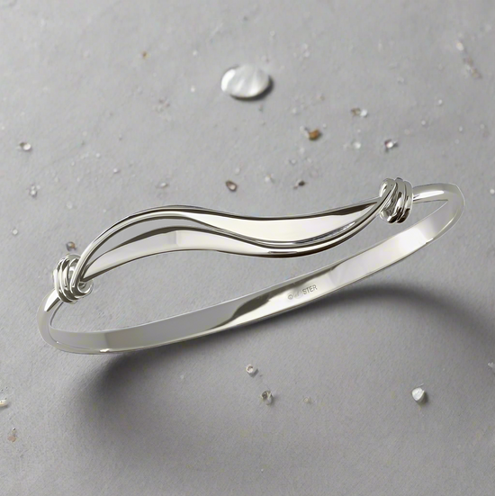 Photo of "Wave" Bracelet in a decorative scene, designed by , available at Plumb Gold & Plumb Silver