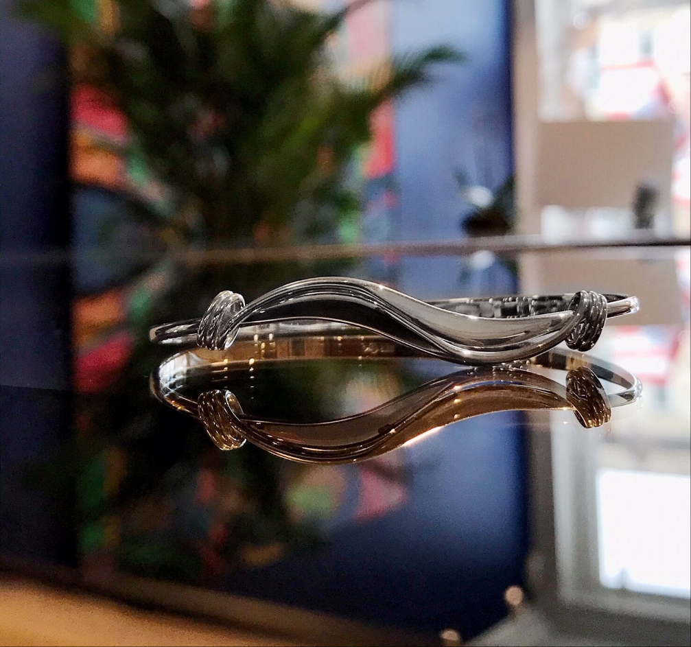 Photo of "Wave" Bracelet in a decorative scene, designed by , available at Plumb Gold & Plumb Silver