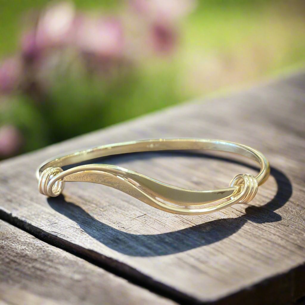 Photo of Wave Bracelet in a decorative scene, designed by , available at Plumb Gold & Plumb Silver