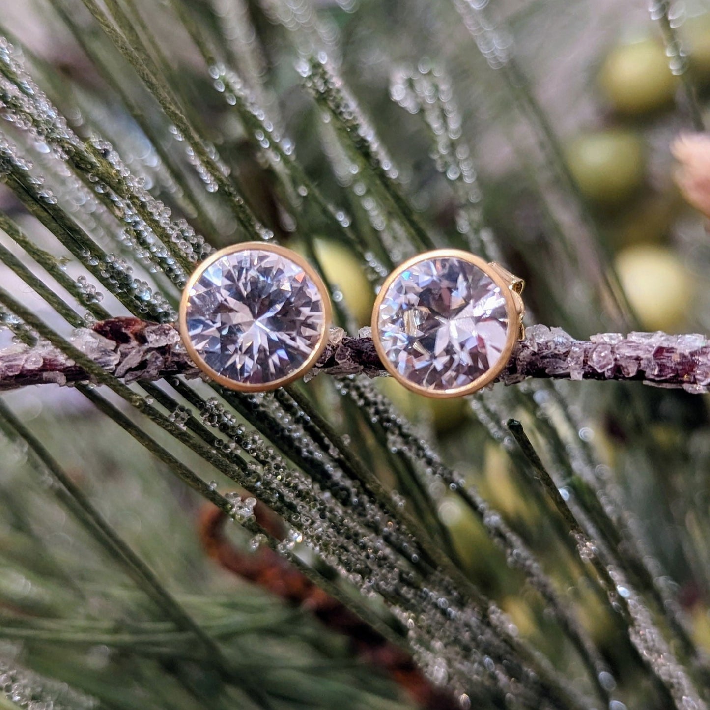 Photo of White Zircon Bezel Studs in a decorative scene, designed by , available at Plumb Gold & Plumb Silver