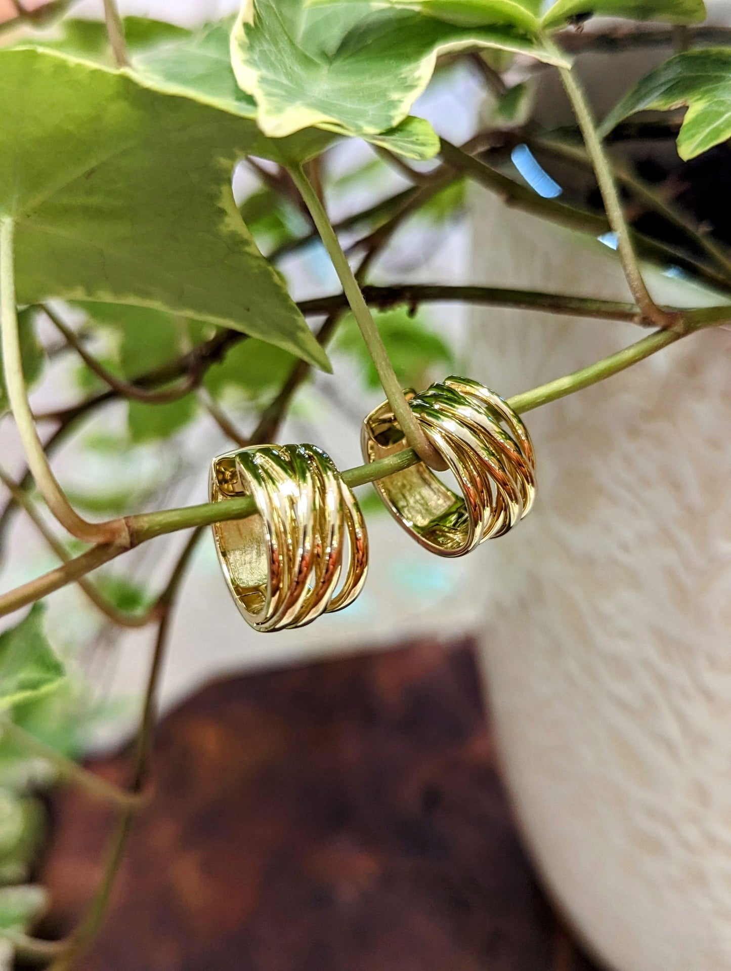 Photo of Wide Crossover Huggies in a decorative scene, designed by , available at Plumb Gold & Plumb Silver