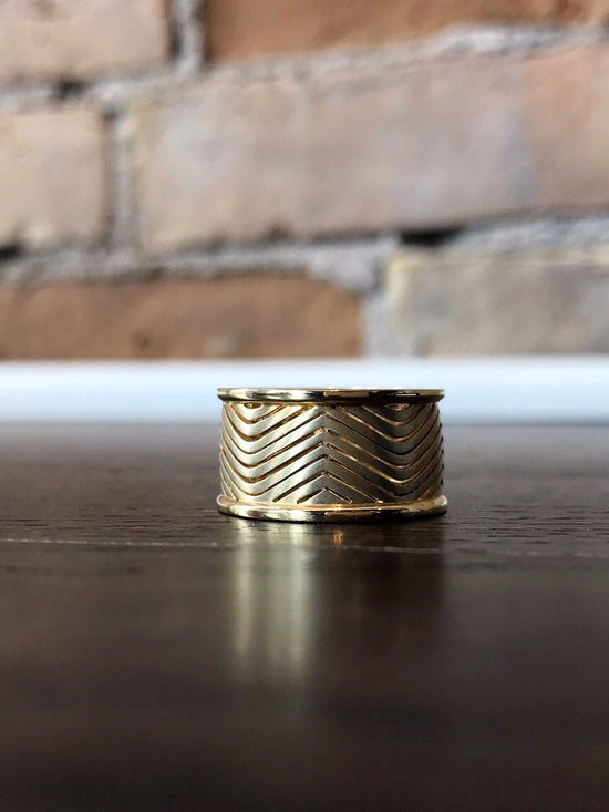 Photo of Wide Herringbone Ring in a decorative scene, designed by , available at Plumb Gold & Plumb Silver
