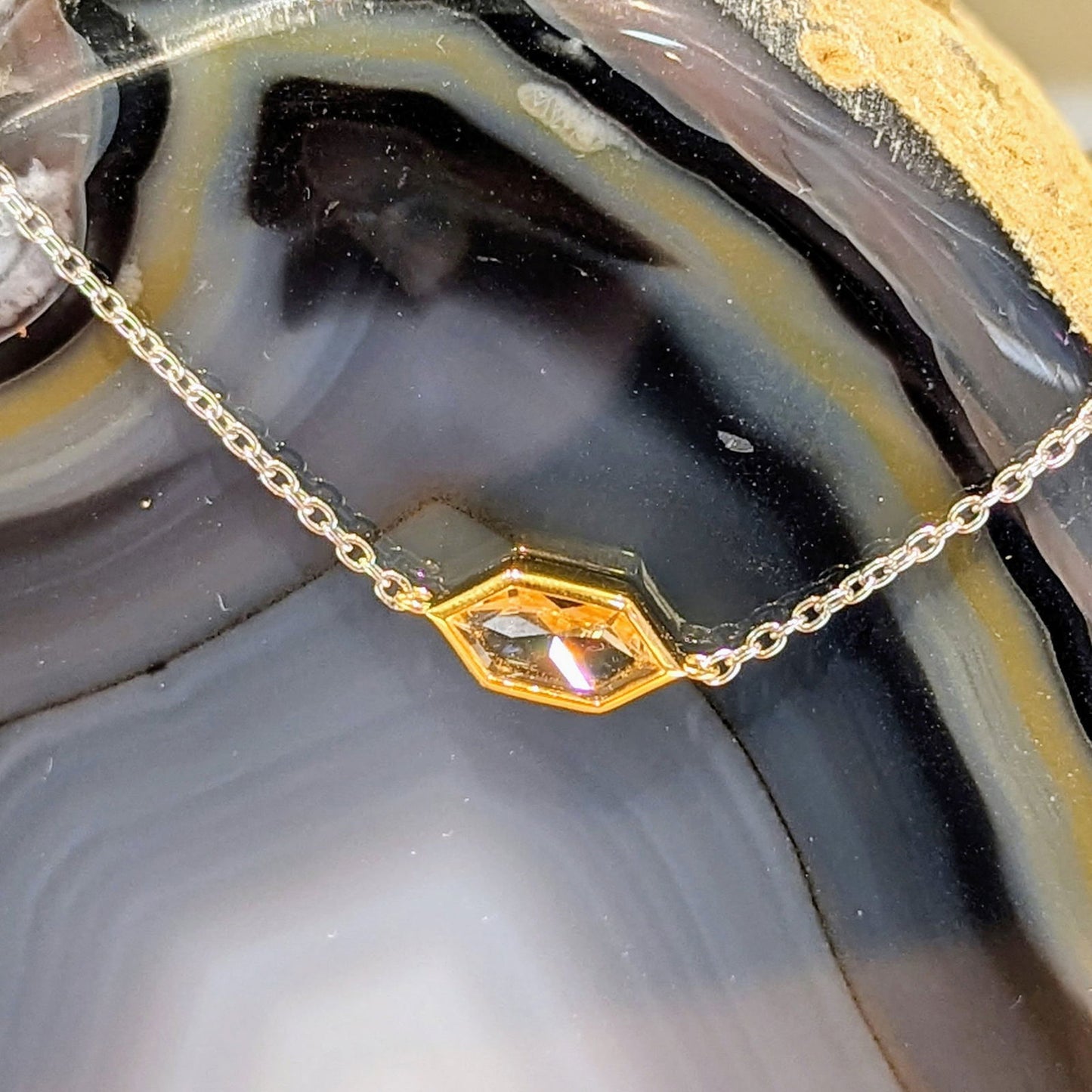 Photo of Yellow gold Plate Accented CZ Hexagon Bracelet in a decorative scene, designed by , available at Plumb Gold & Plumb Silver