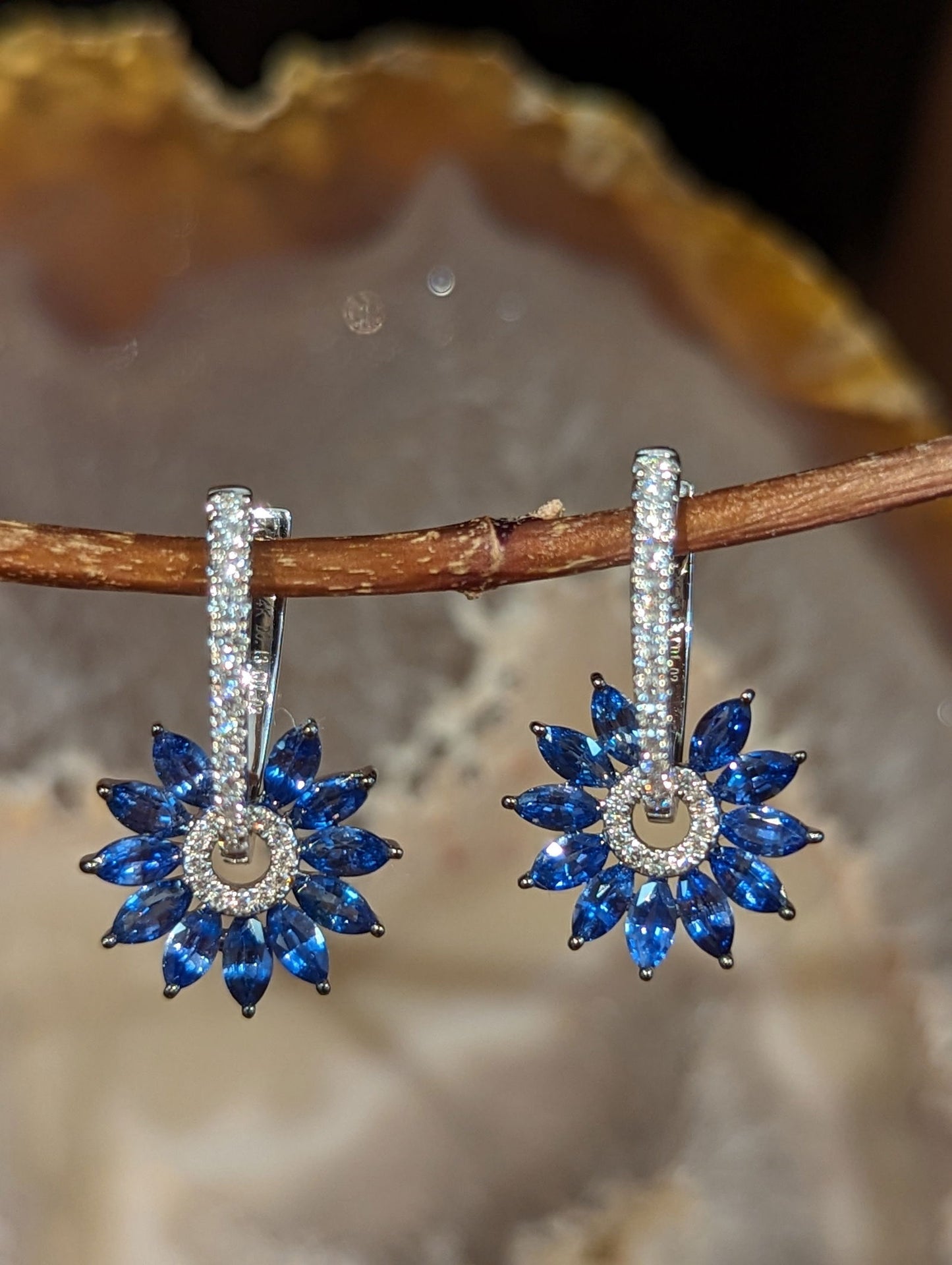 Photo of Zeghani Sapphire & Diamond Burst Hoops in a decorative scene, designed by , available at Plumb Gold & Plumb Silver