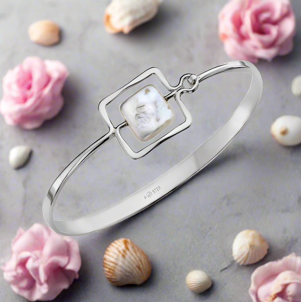 Photo of "Zenith" Bangle in a decorative scene, designed by , available at Plumb Gold & Plumb Silver