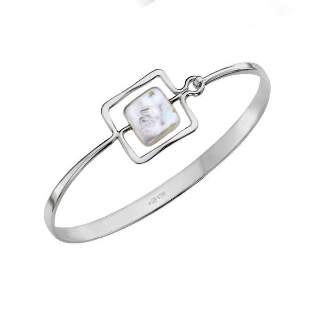 Photo of "Zenith" Bangle in a decorative scene, designed by , available at Plumb Gold & Plumb Silver
