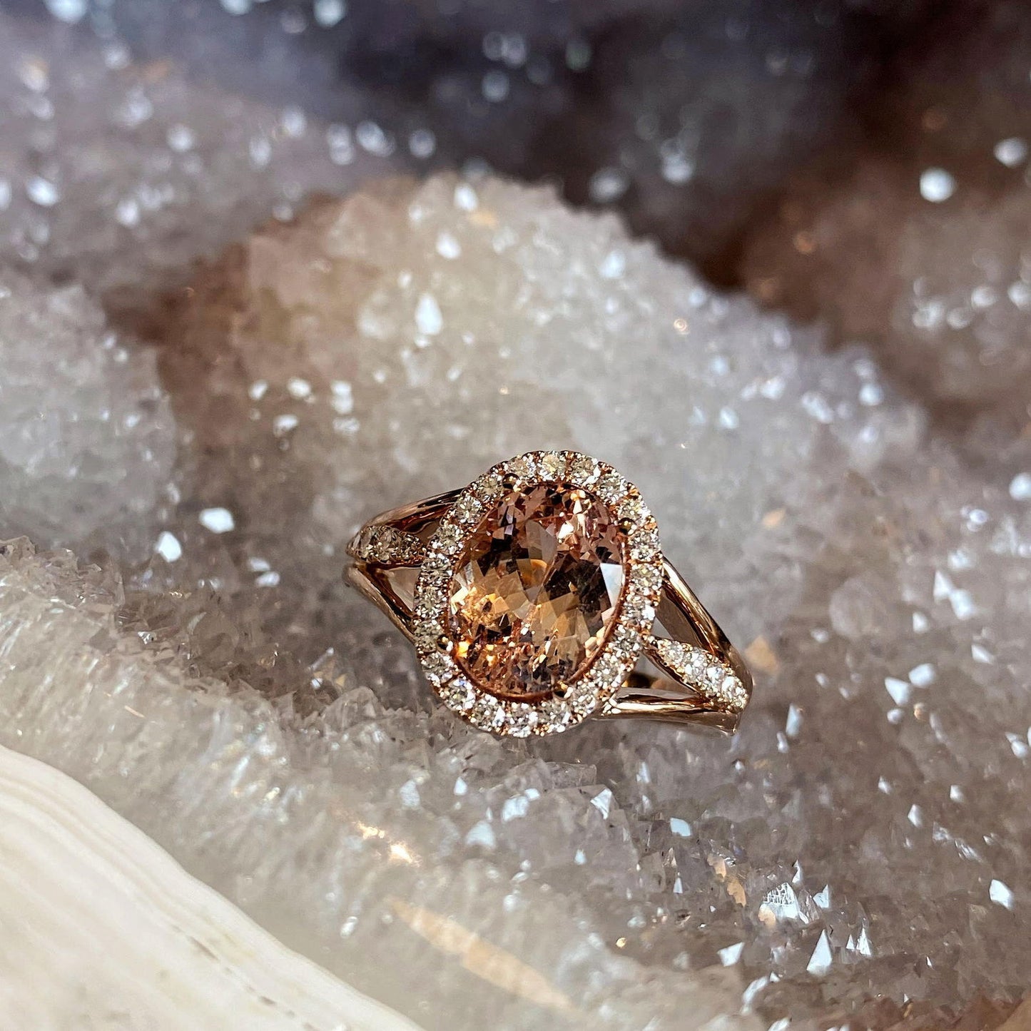 Photo of Zoma Color Malaya Garnet &amp; Diamond Halo Ring in a decorative scene, designed by , available at Plumb Gold & Plumb Silver