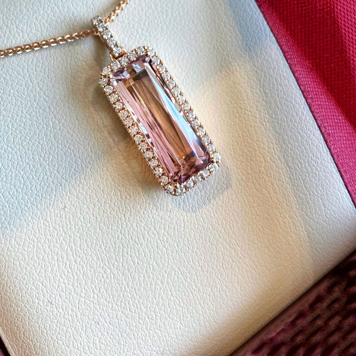 Photo of Zoma Color Pink Tourmaline &amp; Diamond Pendant in a decorative scene, designed by , available at Plumb Gold & Plumb Silver
